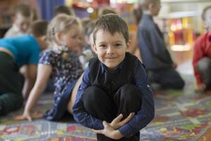 Six-year-old child on the background of other children. The boy is a preschooler. photo