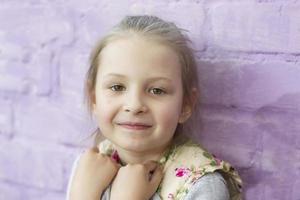 . retrato de un hermosa preescolar niña en un púrpura antecedentes. foto