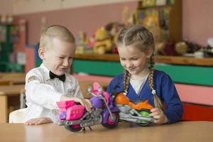 Children of elementary age play. Boy and girl from kindergarten with toy cars. photo