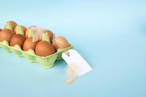 pollo marrón huevos en un reciclado cartulina bandeja con un precio etiqueta etiqueta. conjunto de huevos con etiqueta foto