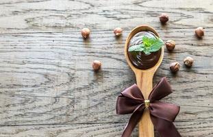 de madera cuchara de chocolate crema con Fresco menta foto