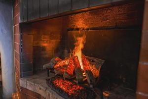 de cerca de leña ardiente en hogar en hotel habitación foto