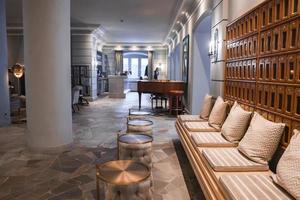 Cushions arranged on empty benches with ottomans in hotel lobby photo