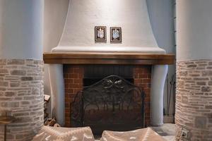 Empty ottomans in front of fireplace in hotel room photo