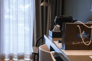 Coffee machine with cups and shopping bag on table in luxury bedroom photo