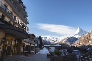 Exterior of hotel building with beausite sign and beautiful mountains photo