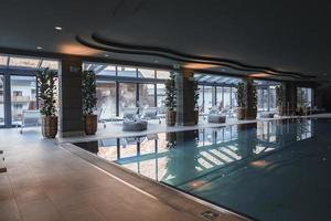 Potted plants by columns in front of swimming pool at luxury hotel photo