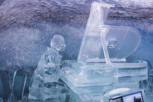 Ice statue of man playing piano in glacier tunnel photo