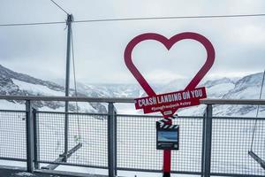 Red heart shape with text against beautiful snowcapped mountains photo