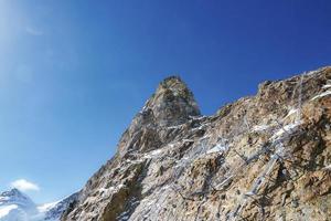 hermosa rocoso montaña con metálico estructura debajo claro cielo foto