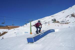 Tourist snowboarding on snow mountain during vacation photo