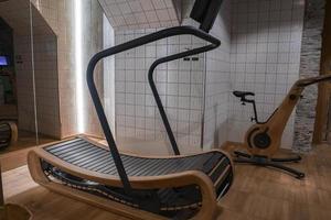 Wooden treadmill with cycle in empty gym at luxury hotel photo