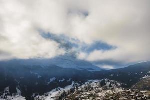 nieve cubierto majestuoso bernés montaña pico debajo Cloudscape durante invierno foto