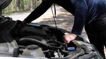 une homme corrige une auto. ouvert voiture capot. fermer. video