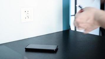 A woman plugs her phone into a wired charger video