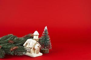 christmas card. Christmas tree and cute cottage on a red background. photo