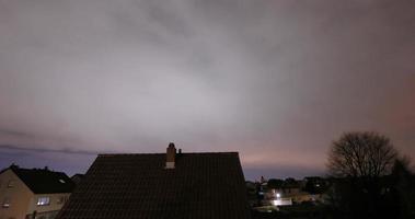 Time lapse movie of low moving cloud cover over a settlement at night video