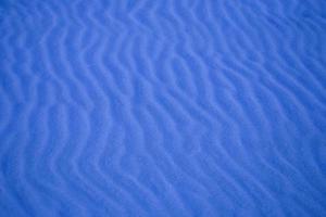 blue background with sand in the shape of sand waves photo