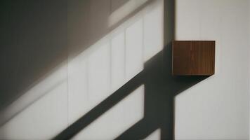 A wooden cube on a wall with the light coming through the window photo