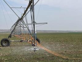 Irrigation system watering the field with a high pressure water jet photo