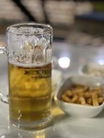 vaso de cerveza y meriendas en el mesa en un pub o restaurante foto