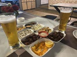 meriendas y cerveza en el mesa en un pub. cerca arriba foto