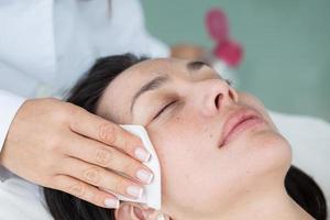 Doctor cleaning a woman patient face photo