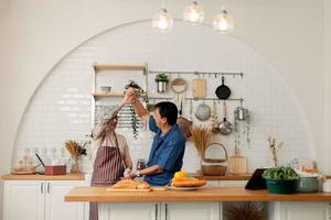 An elderly couple having a meal together. Senior couple having fun cooking together in the kitchen. healthy lifestyle concept happy family Happy time, holiday, cooking photo