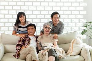 happy family. happy family Asian family, parents and children Happy sitting on the sofa in the house. The family relaxes on the sofa in the living room. photo