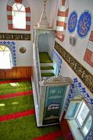 modest simple interior of a small Turkish village mosque with one miner photo