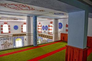 modest simple interior of a small Turkish village mosque with one miner photo