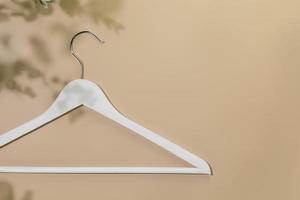 White wooden hanger on beige background with copy space photo