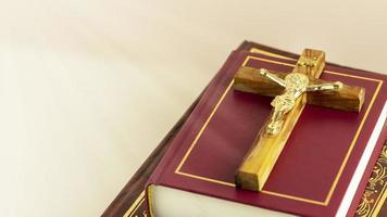 Crucifix with Christian bibles on a light gradient background with divine light photo