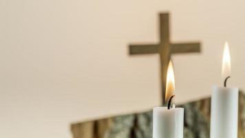 Wooden cross with white candles on gradient background with copy space. photo