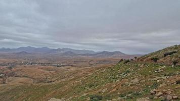 empty mysterious mountainous landscape from the center of the Canary Island Spanish Fuerteventura with a cloudy sky photo