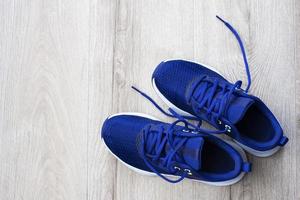 A pair of blue sneakers on a light wooden laminate. Sports theme without people. photo