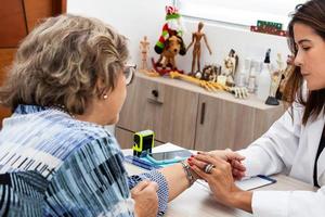 traumatólogo hembra médico a su oficina examinando un mayor hembra paciente. esqueleto hueso enfermedad examen y médico ayuda. carrera concepto. foto