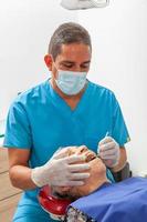 Male middle -aged dentist at his office with a senior woman patient photo