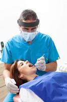 Male middle-aged dentist at his office with a female patient photo