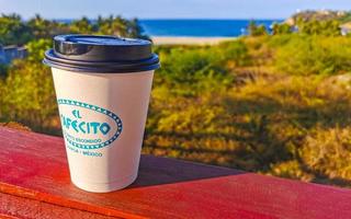 Puerto Escondido Oaxaca Mexico 2023 Coffee to go mug on the beach sand sea waves. photo