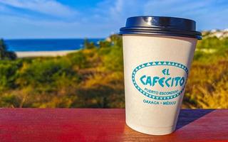 Puerto Escondido Oaxaca Mexico 2023 Coffee to go mug on the beach sand sea waves. photo