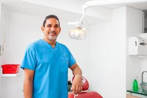 Portrait of a male middle -aged dentist at his office photo