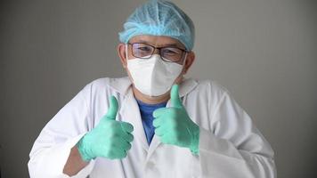 gelukkig glimlachen tevreden chirurg, vertrouwen dokter tonen duimen omhoog teken, geslaagd professioneel medisch behandeling kliniek of ziekenhuis concept video
