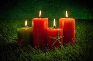 Advent candle, fir tree branches and holiday decorations in snow against light garland background. Christmas card. . photo