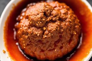 Meatballs with tomato sauce on a white plate, close-up. photo