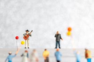 miniatura cantante y músico jugando un guitarra en escenario, mundo música día concepto foto