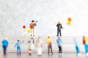 miniatura cantante y músico jugando un guitarra en escenario, mundo música día concepto foto