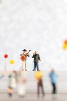 miniatura cantante y músico jugando un guitarra en escenario, mundo música día concepto foto