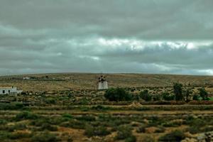 vacío misterioso montañoso paisaje desde el centrar de el canario isla Español fuerteventura con un nublado cielo y original molinos de viento foto