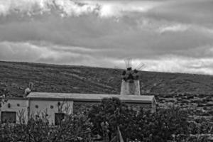 empty mysterious mountainous landscape from the center of the Canary Island Spanish Fuerteventura with a cloudy sky and original windmills photo